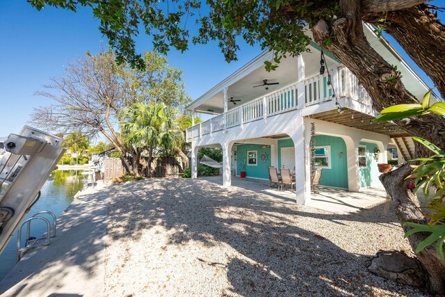 22738 Blackbeard Ln, Cudjoe, FL 33042 - view of side of property with ceiling fan, a patio area, and a boat dock