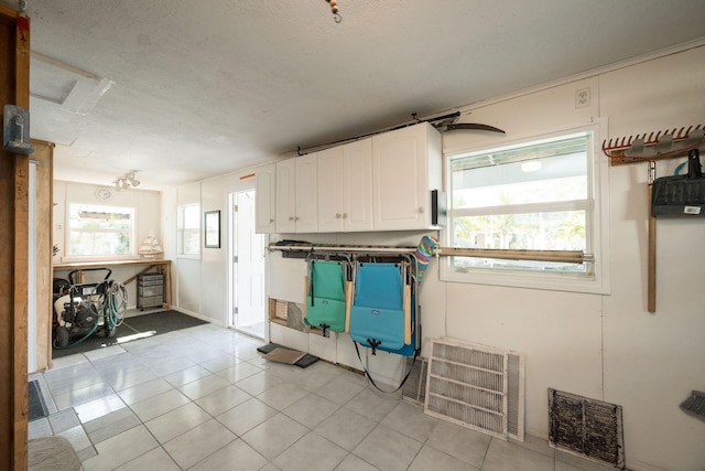 22738 Blackbeard Ln, Cudjoe, FL 33042 - kitchen featuring white cabinetry, light tile patterned floors, and a textured ceiling