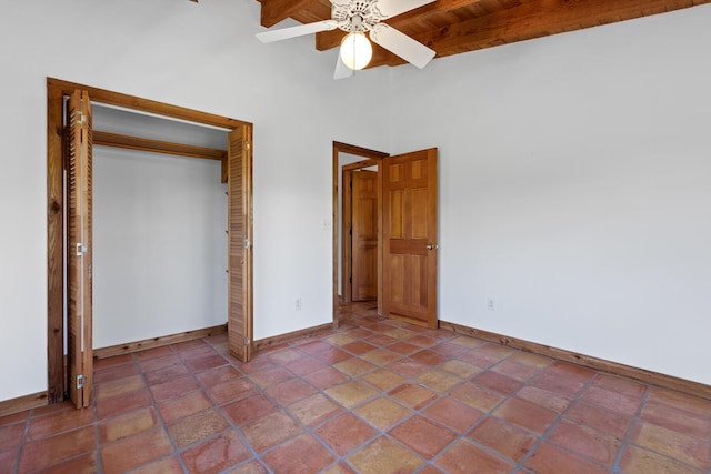 unfurnished bedroom featuring beamed ceiling, ceiling fan, and a closet