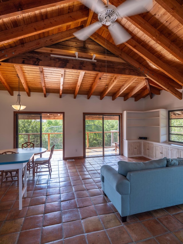 unfurnished living room with lofted ceiling with beams, ceiling fan, plenty of natural light, and wood ceiling