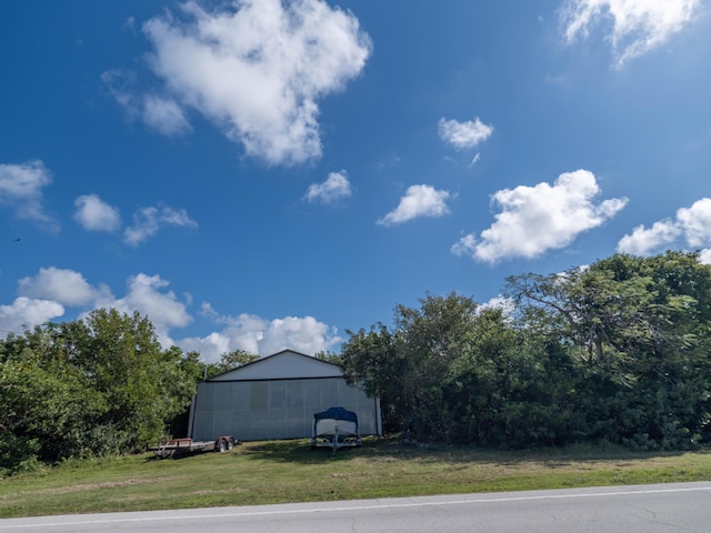 view of side of home featuring an outbuilding and a yard