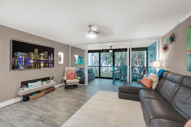 living room with crown molding, ceiling fan, floor to ceiling windows, and wood-type flooring