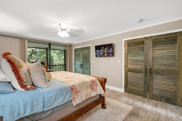 bedroom featuring ornamental molding, ceiling fan, a textured ceiling, and light wood-type flooring