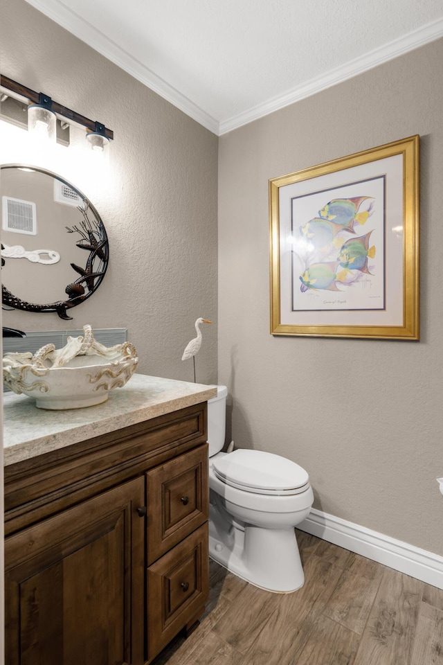 bathroom featuring crown molding, vanity, toilet, and hardwood / wood-style floors