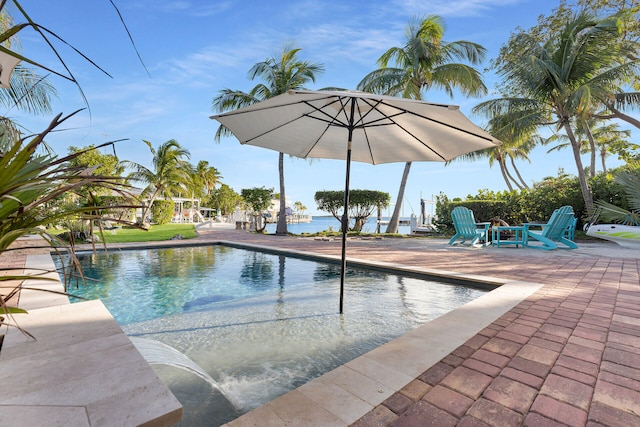 view of swimming pool with a patio area and a water view