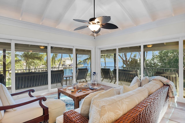 sunroom / solarium with ceiling fan, a water view, and beam ceiling