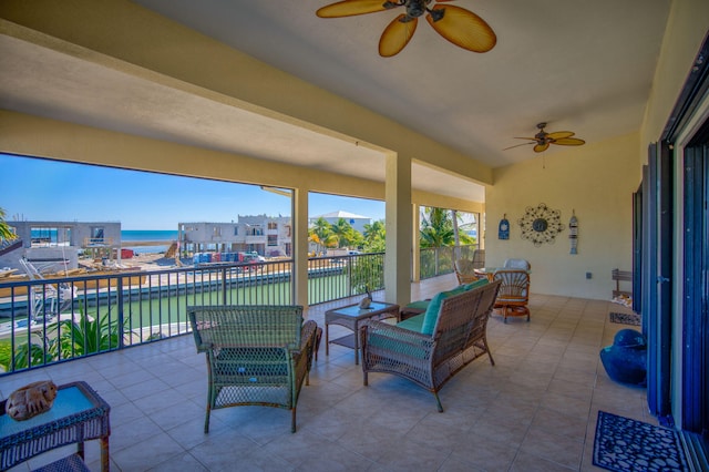 sunroom with a water view and ceiling fan