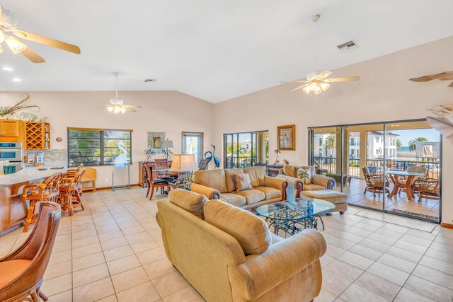 living room with light tile patterned flooring, ceiling fan, and a wealth of natural light