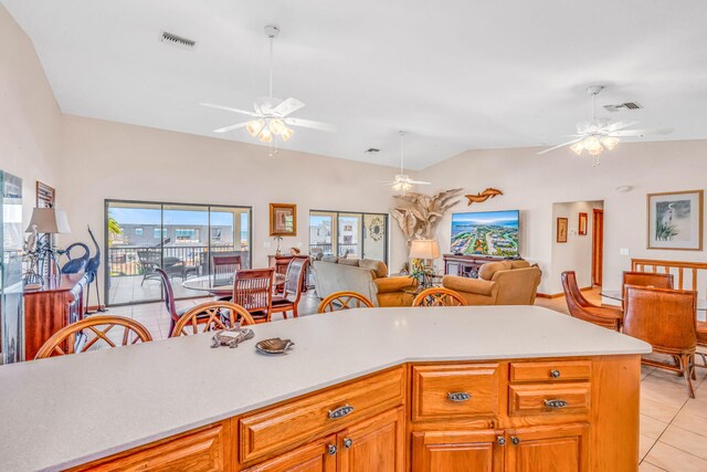 kitchen with vaulted ceiling, light tile patterned floors, and ceiling fan