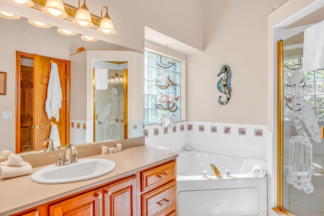 bathroom featuring a healthy amount of sunlight, vanity, and independent shower and bath