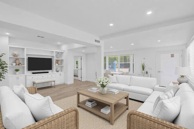 living area with baseboards, light wood-type flooring, visible vents, and recessed lighting