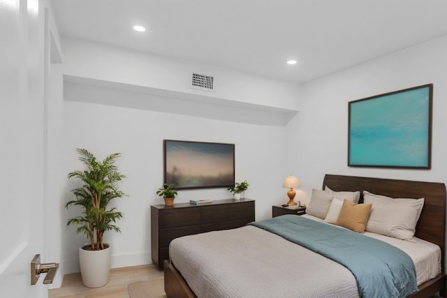 bedroom with baseboards, light wood-style flooring, visible vents, and recessed lighting