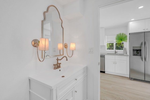 interior space featuring light wood finished floors, a sink, and recessed lighting