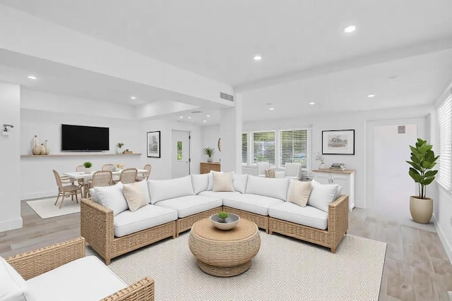 living area with baseboards, light wood finished floors, visible vents, and recessed lighting