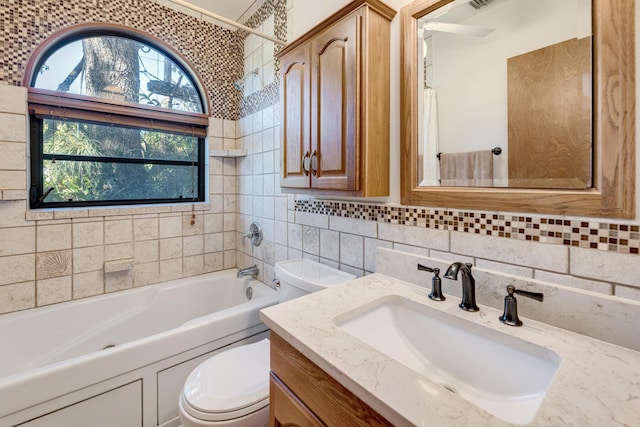 bathroom with toilet, vanity, tile walls, tub / shower combination, and backsplash