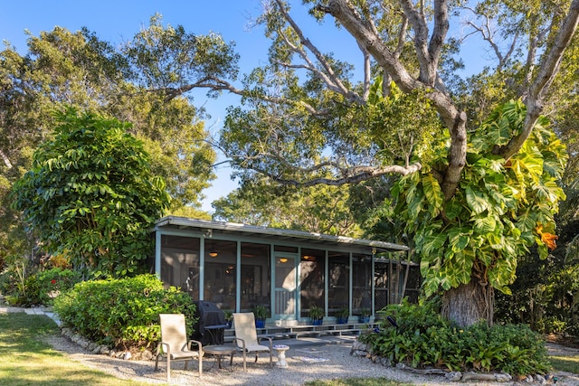 rear view of property with a sunroom and a patio area