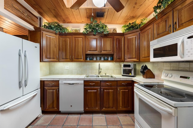 kitchen with white appliances, visible vents, tile countertops, wooden ceiling, and a sink