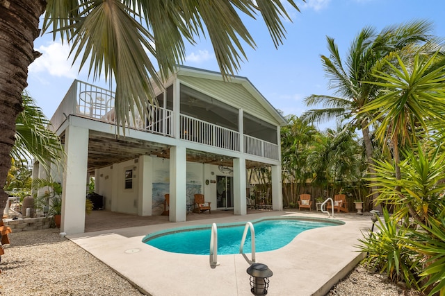 view of swimming pool with a patio area and a sunroom