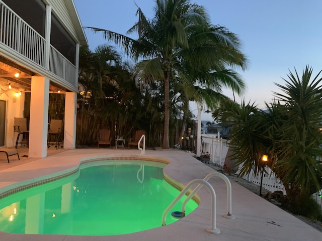 pool at dusk with a patio