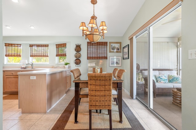 dining space with a notable chandelier, sink, and light tile patterned flooring