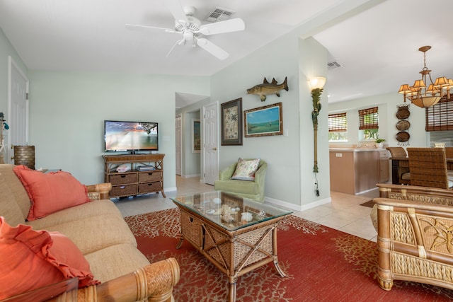 living room featuring light tile patterned floors, ceiling fan with notable chandelier, and vaulted ceiling