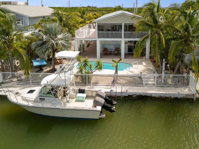 rear view of property with a fenced in pool, a patio area, and a water view