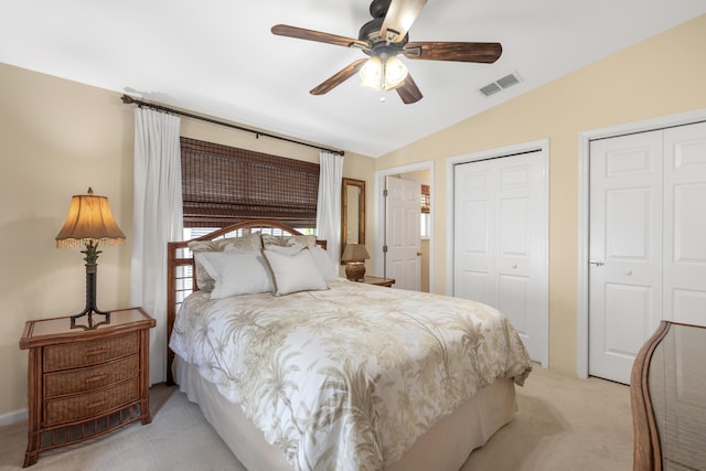 carpeted bedroom with multiple closets, ceiling fan, and lofted ceiling