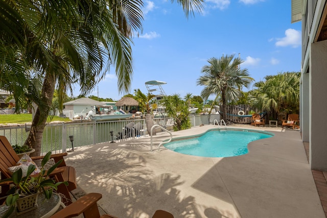 view of swimming pool with a patio area and a water view