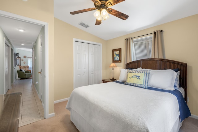 carpeted bedroom with vaulted ceiling, ceiling fan, and a closet