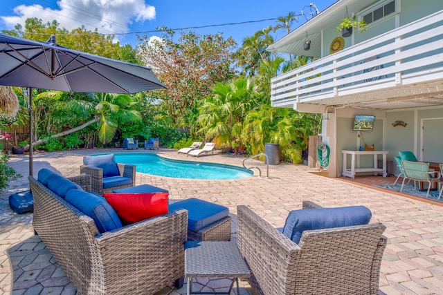 pool with an outdoor living space and a patio