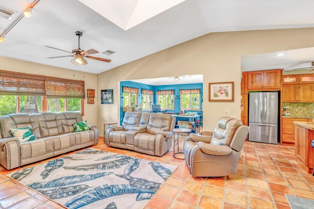 living room with light tile patterned floors, visible vents, a ceiling fan, and vaulted ceiling