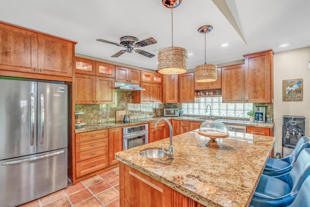 kitchen featuring a sink, stainless steel appliances, under cabinet range hood, and decorative backsplash