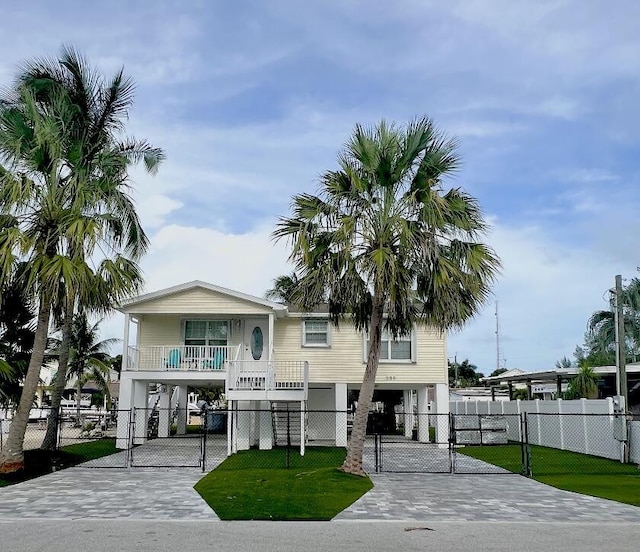 coastal home featuring covered porch and a front yard