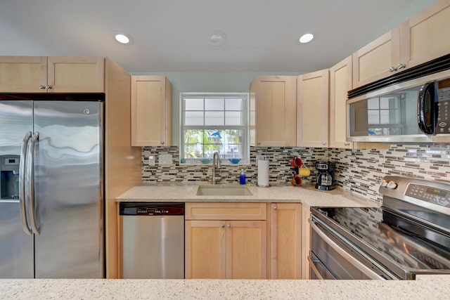 kitchen with tasteful backsplash, sink, stainless steel appliances, and light brown cabinets