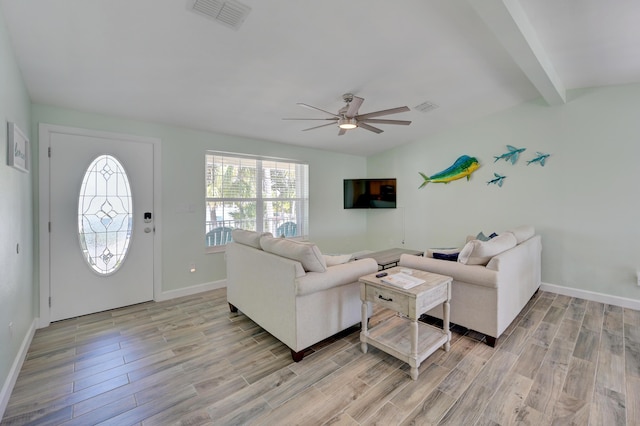 living room with ceiling fan, light hardwood / wood-style floors, and beamed ceiling