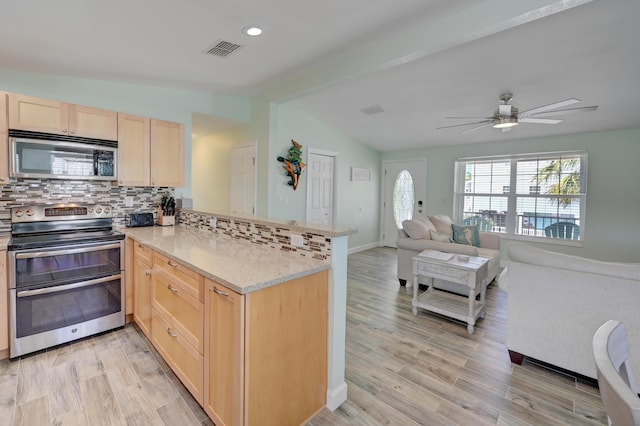 kitchen featuring tasteful backsplash, appliances with stainless steel finishes, light brown cabinetry, and kitchen peninsula