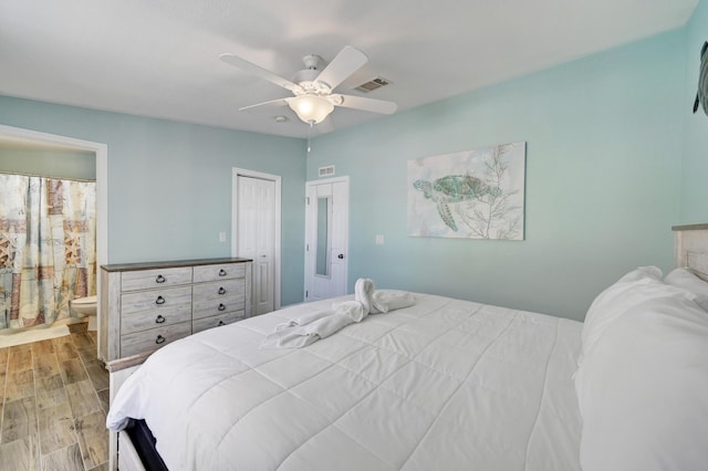 bedroom with ceiling fan, a closet, light wood-type flooring, and ensuite bath