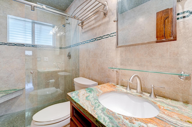 bathroom with vanity, tile walls, walk in shower, and toilet