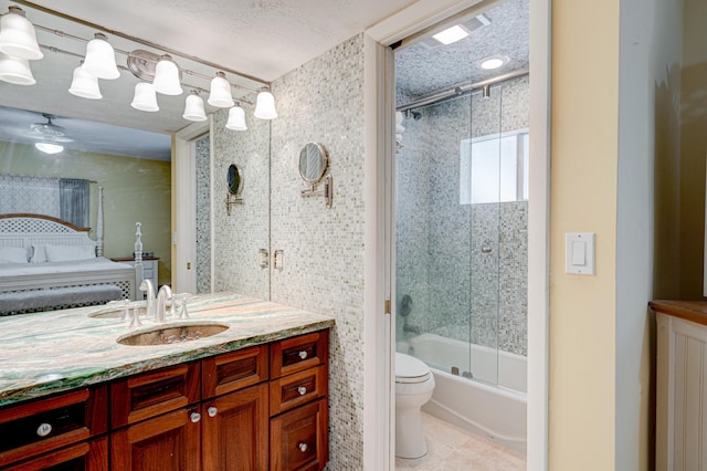 full bathroom with shower / bath combination with glass door, vanity, a textured ceiling, tile patterned floors, and toilet