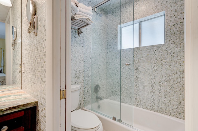 full bathroom featuring vanity, toilet, and combined bath / shower with glass door