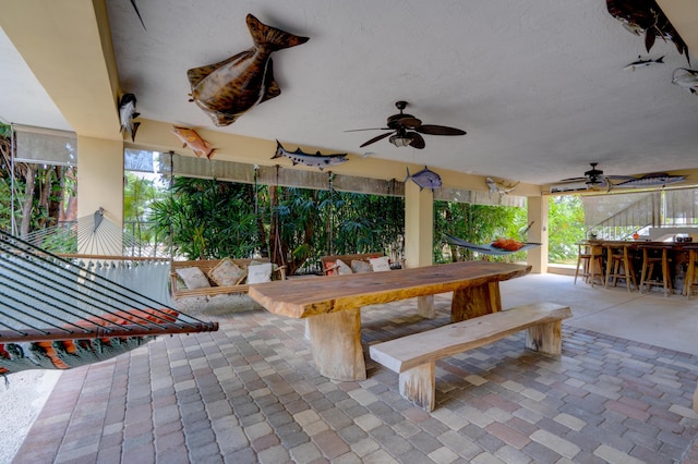 view of patio featuring ceiling fan and an outdoor bar