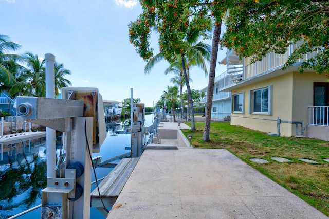 view of dock featuring a lawn and a water view