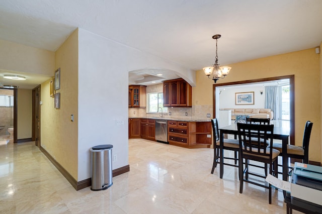 dining space with sink and a notable chandelier