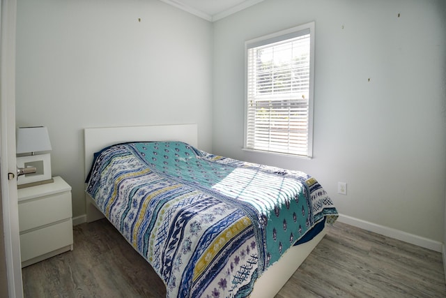 bedroom featuring ornamental molding and dark hardwood / wood-style flooring