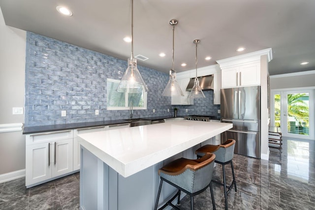 kitchen featuring decorative backsplash, freestanding refrigerator, and marble finish floor