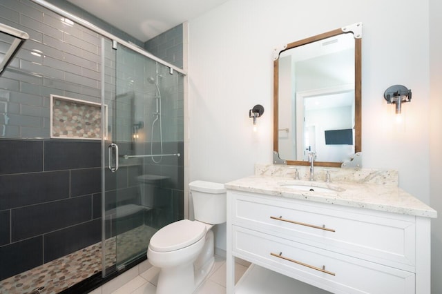 bathroom with a shower stall, toilet, vanity, and tile patterned floors