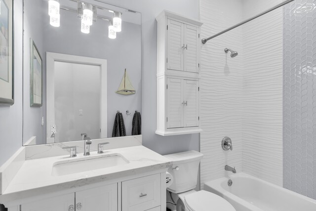 full bathroom featuring vanity, tiled shower / bath, and toilet