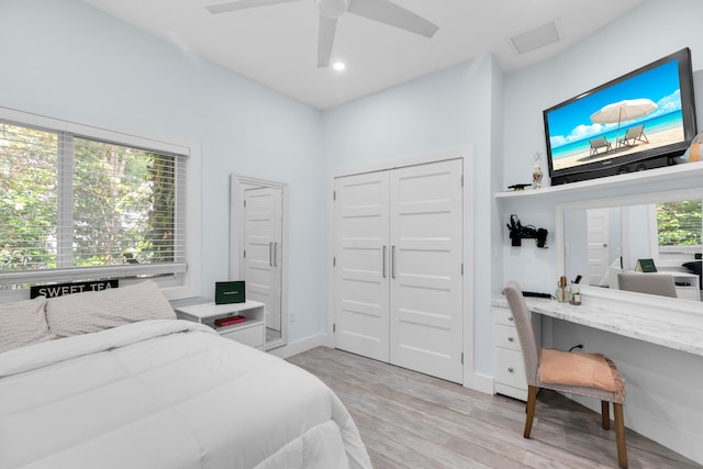 bedroom featuring ceiling fan, light wood-type flooring, and a closet