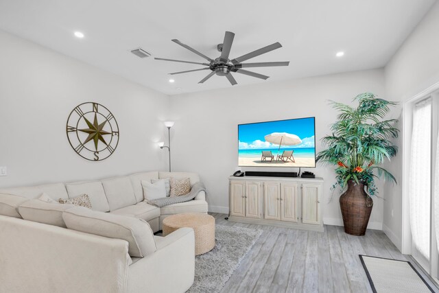 living room with light hardwood / wood-style flooring and ceiling fan