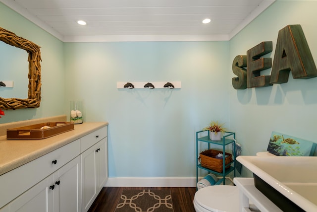 bathroom featuring wood-type flooring, toilet, and vanity